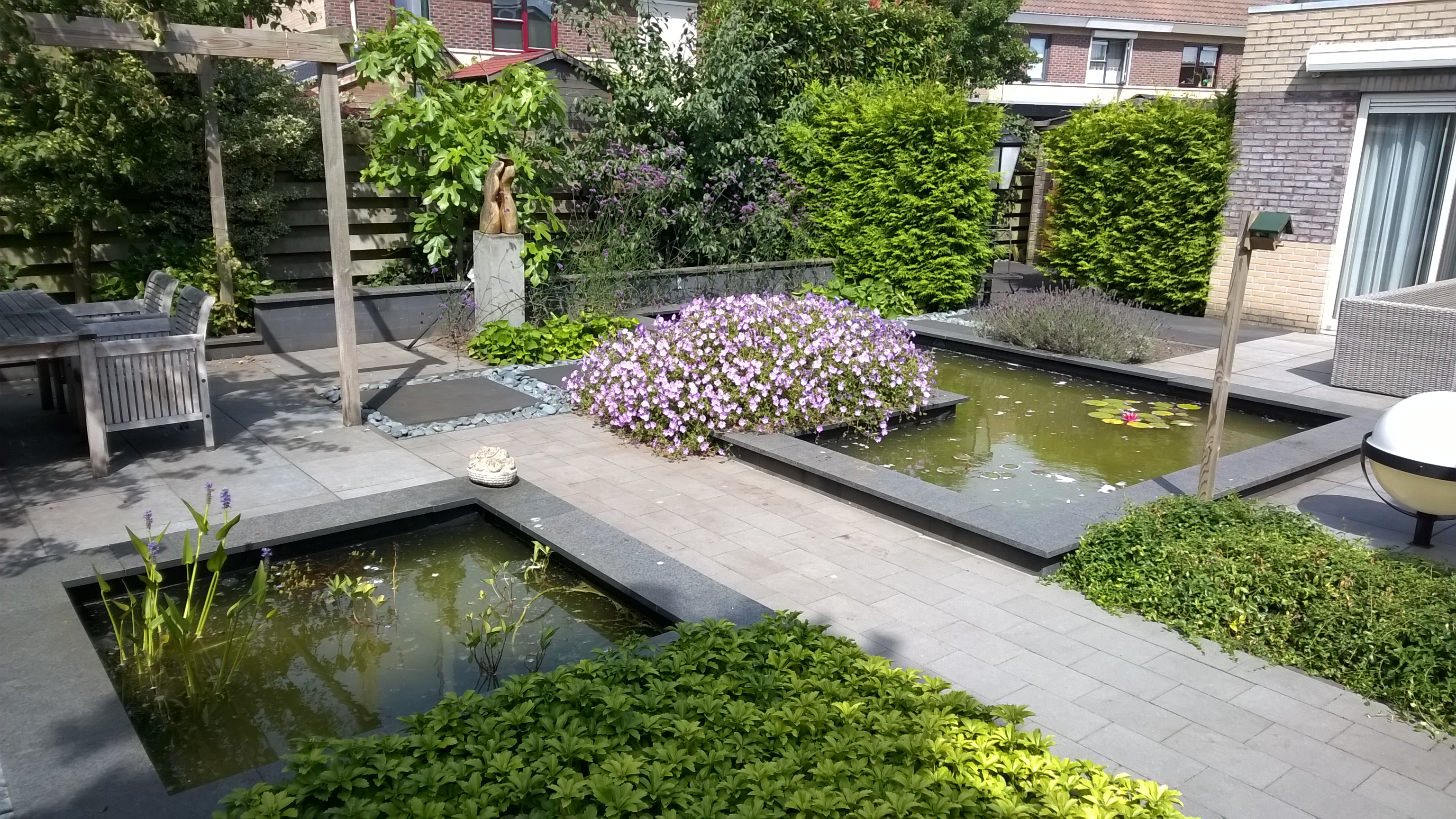 Een achtertuin met prachtige vijverpartij in Wezep
